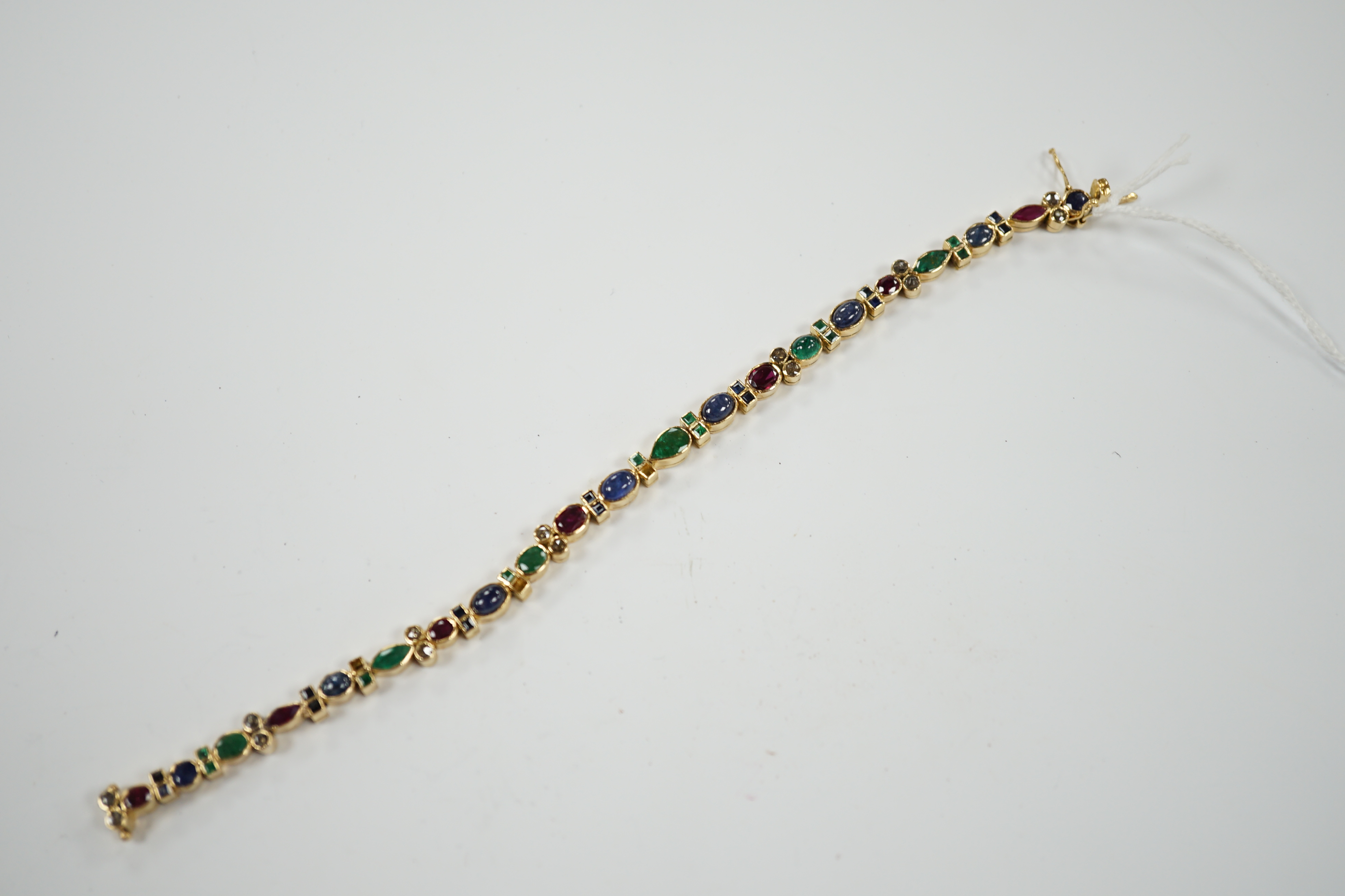 A yellow metal, diamond, ruby, sapphire and emerald cluster set line bracelet, 18.6cm, gross weight 18.3 grams.